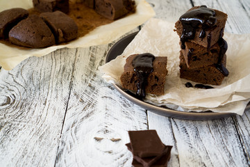 Chocolate Brownie on paper on white-brown rustic background with copy space
