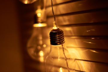 Garland of vintage bulb lamps with modern yellow LED lighting elements, close up photo