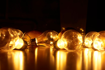 Garland of vintage bulb lamps with modern yellow LED lighting elements, close up photo