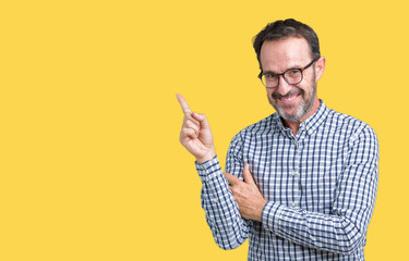 Handsome middle age elegant senior business man wearing glasses over isolated background with a big smile on face, pointing with hand and finger to the side looking at the camera.