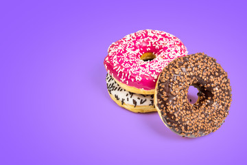 Sweet donuts isolated on violet background