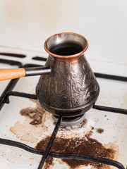 Cooking natural coffee. Coffee in Turk on the gas stove boiled away. Dirty stove. The incident in the kitchen