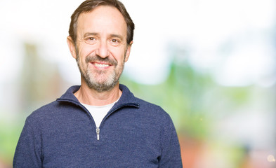 Middle age handsome man wearing a sweater with a happy and cool smile on face. Lucky person.