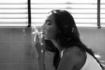 The sexy woman sitting in bathroom,smoking,loneliness feeling,black and white tone