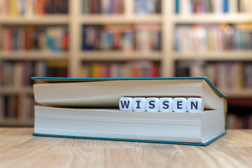 Würfel zwischen Buchseiten bilden das Wort 
