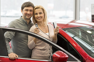 Fototapeta na wymiar Happy mature couple buying a new car