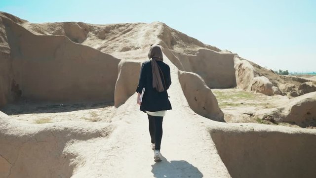 Women walking alongside a archeological sight in Iran.