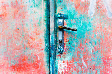 Red grundge metal door with old rusty hinge. Abstract background image
