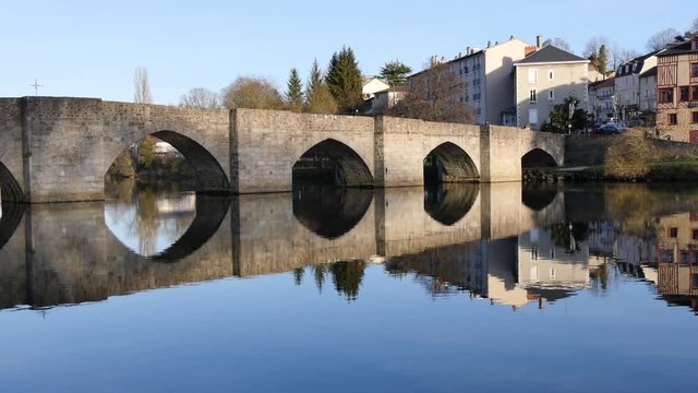Time lapse in Limoges, city of France. The Saint-Étienne bridge is an old and famous medieval bridge in the city. Reflections on the water. View from the river bank. Sunny day in the winter.