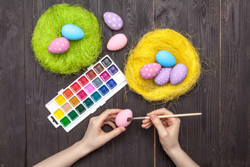 Women painting Easter eggs on table