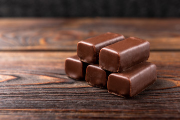 Chocolate sweets with praline on wooden background.