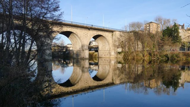 View of the Vienne river in Limoges, city of France. The bridge is called "Pont de la révolution". Reflection on the water. Blue sky, sunny day. Filmed in the winter.