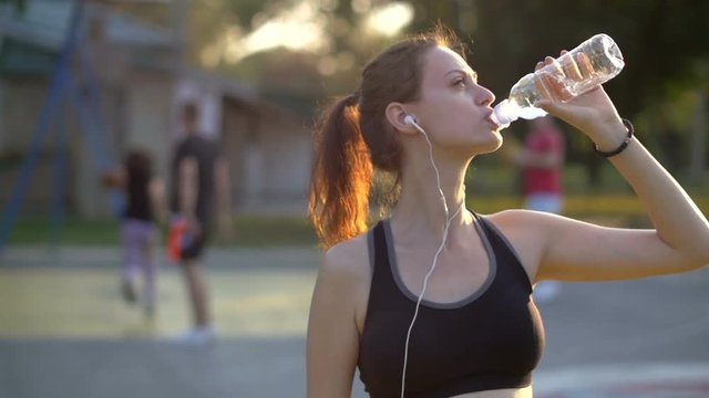 Woman drinking water after sport activities