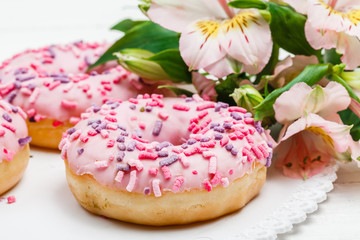 Yummy donuts with berries on the white wooden background. Sweet food. Close up