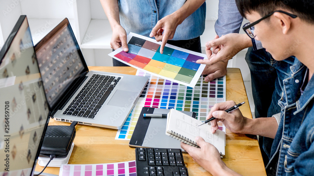 Aufkleber team of young colleagues creative graphic designer working on color selection and drawing on graphic