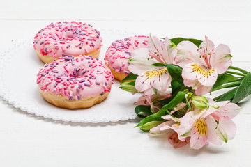 Yummy donuts with berries on the white wooden background. Sweet food. Close up
