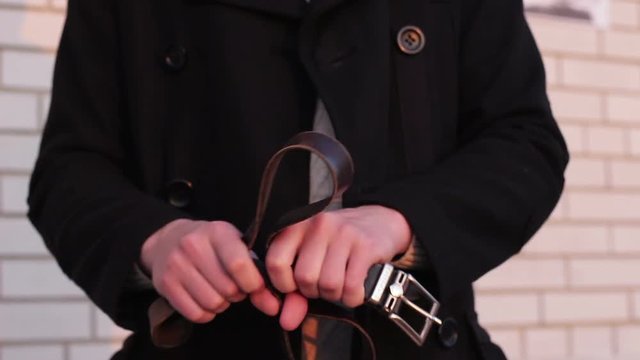 Belt in the hands of a man before punishing a child