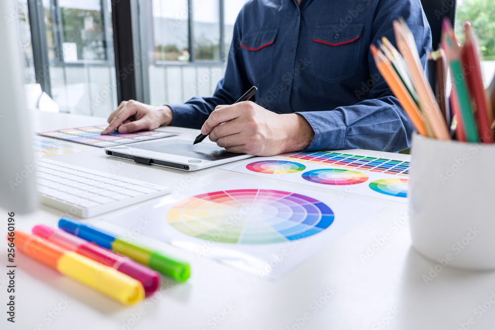 Aufkleber male creative graphic designer working on color selection and color swatches, drawing on graphics ta
