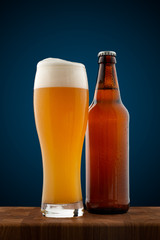 a glass full of cold beer and a beer bottle