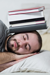 Obraz premium Young man is sleeping on his books. White background