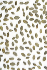 Pipas de calabaza peladas sobre fondo blanco, composición como fondo