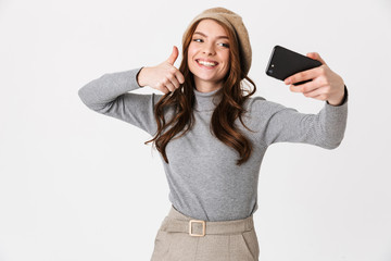 Naklejka premium Happy woman isolated over white wall background take selfie by mobile phone.