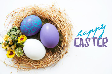 Multi-colored Easter eggs in nest on wooden background, selective focus image. Happy Easter card