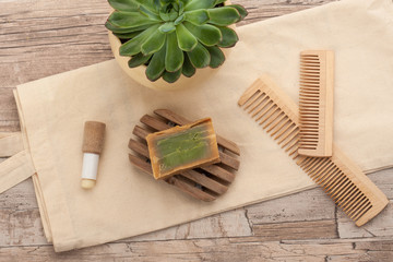 Zero waste bathroom essentials: recyclable wooden combs made out of bamboo, oragnic hand soap and a textile shopping bag. Shea butter lip balm in a biodegradable container.