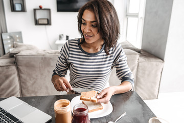 Smiling young african woman having breakfast