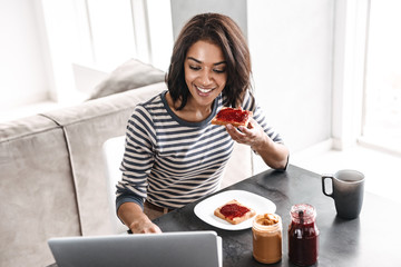 Smiling young african woman having breakfast