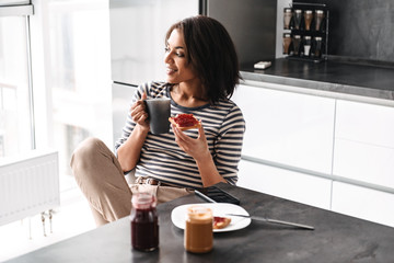 Beautiful young african woman having breakfast