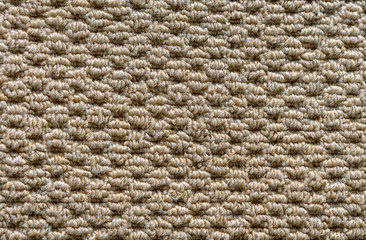 Texture of a beige carpet with a large nap.