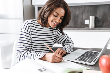 Attractive young african woman using laptop computer