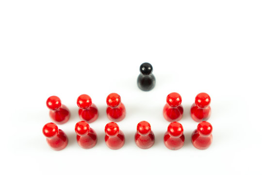 Many red meeple in a row and a black meeple leaving the red ones, white background and copy space