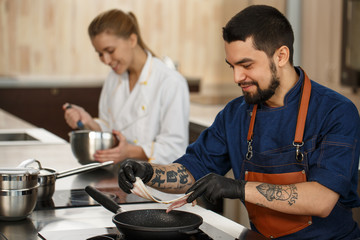 Professional chef and his assistant at the kitchen