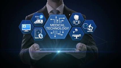 Businessman lifting smart pad, 'MEDICAL TECHNOLOGY' and various future medical vector icon in hexagon, 4k animation. - Powered by Adobe