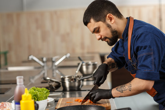 Handsome professional chef cooking at the kitchen