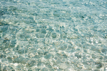 Clear transparent sea water. Natural marine background. Blue ocean wallpaper, sea wave on sunshine day. Crystal clear water of the tropical sea