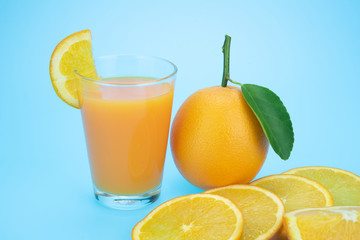 Orange juice and oranges with leaves