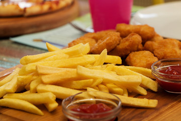 Chicken nuggets, French fries, sauce. Close up. Selective focus.