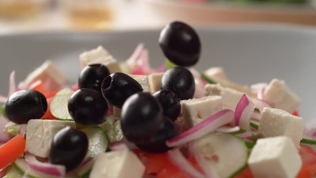 Camera follows putting fresh olive over greek salad. Shot with high speed camera, phantom flex 4K. Slow Motion.