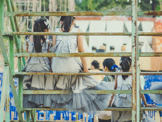 Young girls sit on the grandstand to wait for the stage performance.