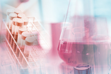 A pipette dropping sample into a test tube,abstract science background