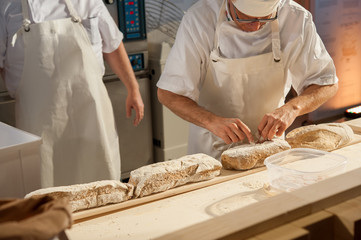 The baker put loaves on the peel before baking