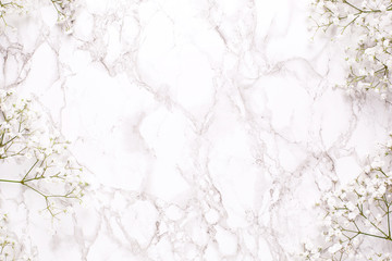 Floral frame of white flowers on marble table top view and flat lay style.