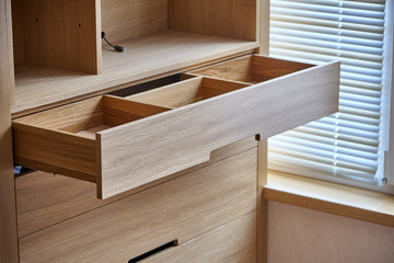 Fototapeta na wymiar Wooden cupboard with opened drawer. Modern furniture
