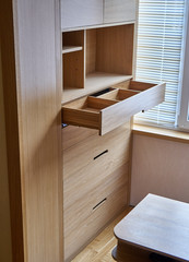 Wooden cupboard with opened drawer. Modern furniture