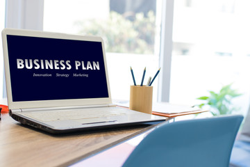 desktop with laptop and business plan concept