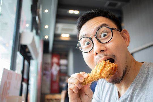 Funny Face Of Man Eat Fried Chicken In The Franchise Cafe.