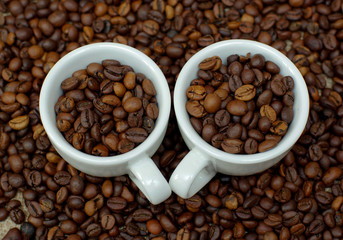 Cup of coffee full of coffee beans. Сoffee cup and coffee beans. Cup full of coffee beans on the cloth sack